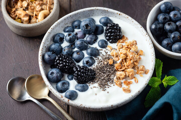Bowl of yogurt with blueberries, blackberries, chia seeds and muesli topping, Healthy eating meal