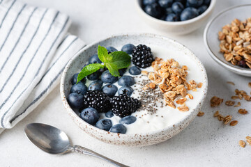 Bowl of yogurt with blueberries, blackberries, chia seeds and muesli topping, Healthy eating meal