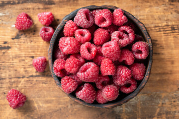 Top view raspberries in a wooden bowl