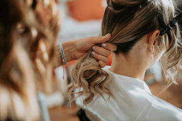 Fototapeta premium La coiffure de la mariée le jour de son mariage pendant ses préparatifs
