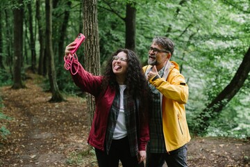 Father daughter taking funny selfie in forest