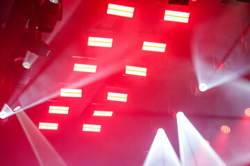 Foto de conjunto de luzes de palco, com muitos fachos de luzes brancas. © Angela