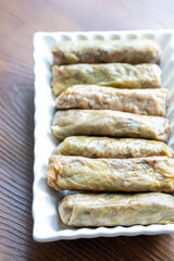 Close-Up of Turkish-Style Cabbage Rolls on a Square Plate on a Brown Table