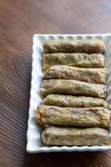 Close-Up of Turkish-Style Cabbage Rolls on a Square Plate on a Brown Table