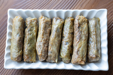 Close-Up of Turkish-Style Cabbage Rolls on a Square Plate on a Brown Table