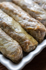 Close-Up of Turkish-Style Cabbage Rolls on a Square Plate on a Brown Table