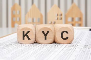 Wooden blocks with KYC abbreviation on financial papers background