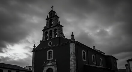 Historic church silhouette under dramatic cloudy sky monochrome photography