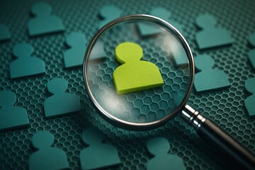 Magnifying glass focusing on green person icon for employee recruitment and selection 
