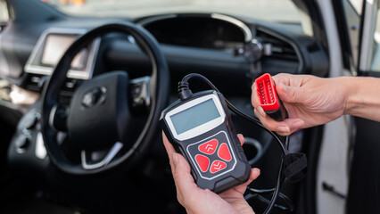 Woman using OBD2 diagnostic scanner. 