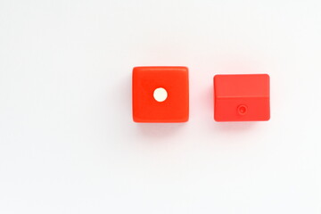 Red dice and plastic house. Close up and shot from above. Concept photo.