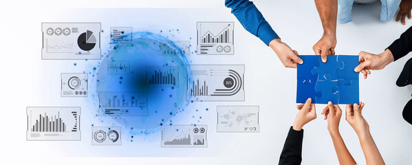 A diverse business team collaborates over data charts and puzzle pieces, symbolizing strategic planning and innovative solutions for future growth in a modern workspace. Trope