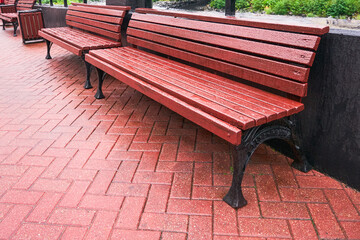 Empty street benches on the street on a rainy day. Outdoor recreation area
