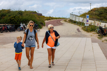 Three generations strolling along a beach path, enjoying quality time together on sunny vacation
