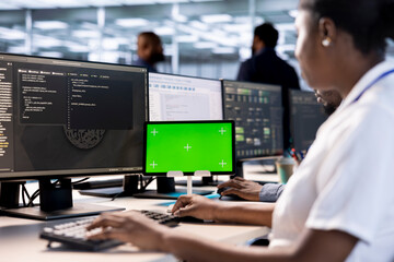 System administrator using green screen tablet to check for signs of failure in data center. African american woman working on mockup device to prevent damages in server farm, monitoring systems