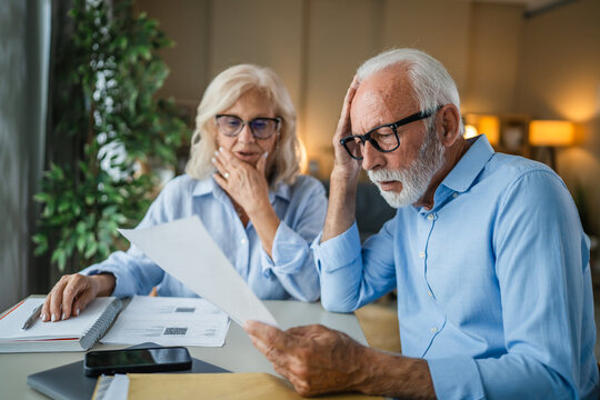 Senior couple analyzing finances experiencing stress and debt problems - Powered by Adobe