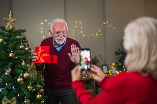 Senior couple making christmas video call on smart phone - Powered by Adobe