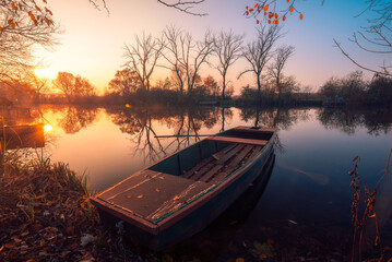 Amazing Hungary. Scenic sunset landscape with boat on the river in autumn. Sunset over the backwater in Gyor, Hungary.