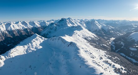 Aerial view of snow covered mountain range under clear blue sky