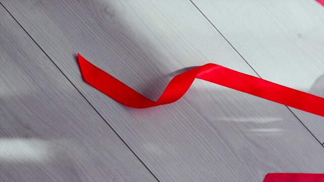 Birthday party.
Chic floor decor.
Long red ribbons in large print on the wooden floor.
Wrapping and gifts.
Christmas and red decor.