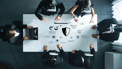 A diverse business team collaborates in a futuristic virtual reality setting, discussing security strategies and analyzing data through high-tech graphics and symbols. Trope