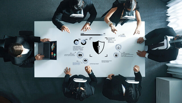 A diverse business team collaborates in a futuristic virtual reality setting, discussing security strategies and analyzing data through high-tech graphics and symbols. Trope