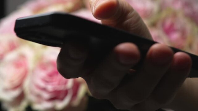 Typing on a mobile phone against the backdrop of a beautiful bouquet of flowers in an interior.
A businessman taps his phone screen to send an SMS.
SMS, typing, businessman, phone