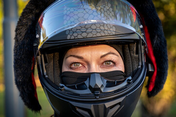 Woman biker wearing a full-face motorcycle helmet with fun black bunny ears