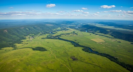 Aerial view of vibrant green landscape with river under blue sky