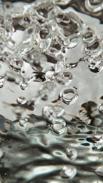 Extreme close-up view of hot water boiling in saucepan. The water creates mesmerizing forms and shapes. Static slow-motion shot