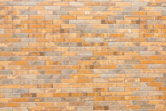 Close-up of orange and brown brick wall surface, showing detailed masonry pattern and texture. Ideal for backgrounds, design, and construction concepts. - Powered by Adobe