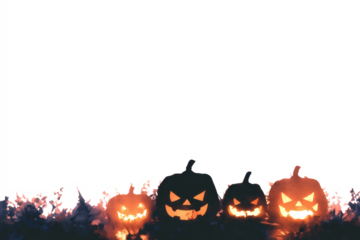 Four illuminated jack-o'-lanterns with carved faces sit in a dark field at dusk.