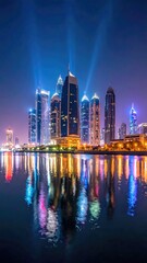 Fototapeta premium Nighttime Urban Skyline with Reflections on Dark Water Tall Buildings Illuminated by Blue Spotlights Creates Striking Visuals