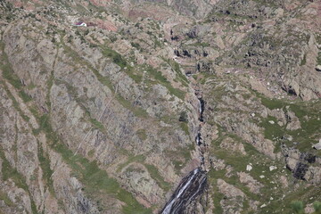 Discover the majestic beauty of a rugged mountain landscape featuring powerful cascading waterfalls...