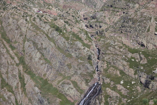 Fototapeta Discover the majestic beauty of a rugged mountain landscape featuring powerful cascading waterfalls and a peaceful cabin retreat