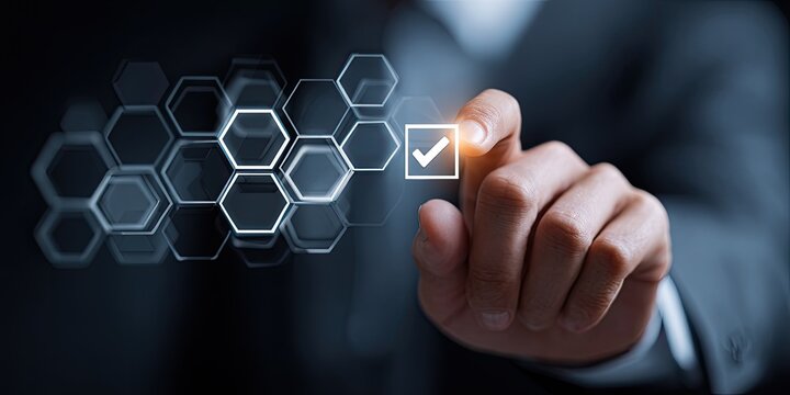 Businessperson's finger touches a digital checkmark interface overlaid with a network of hexagons - Powered by Adobe