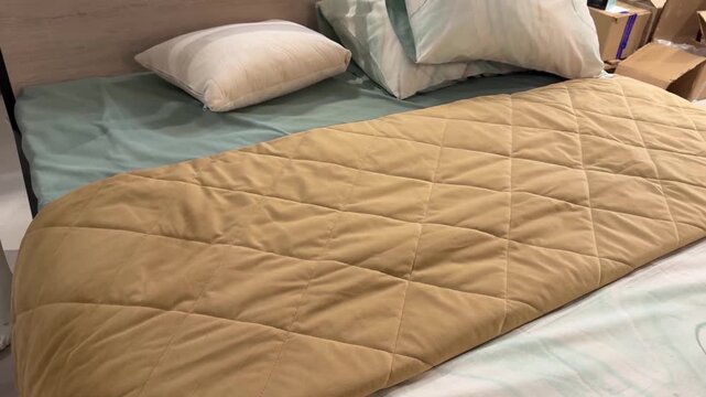 cozy bed with pillows and quilted comforter in bed