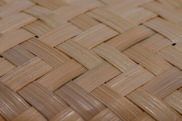 A close-up texture background of traditional woven bamboo. This neat diagonal weaving pattern showcases a classic Southeast Asian handicraft and an eco-friendly, sustainable material.