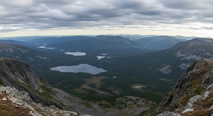 Obraz premium Panoramic view of a vast mountain range with lakes under a cloudy sky