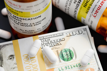 Prescription Medicine Bottles and Pills Next To Stacks of 100 Dollar Bills. The label is non-proprietary - fictional - made specifically for the stock photo industry.