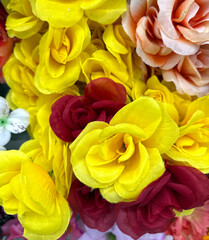 Artificial roses in yellow, red and pink