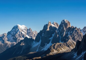 Panoramic landscape of snow-capped mountain with sharp peak under vivid blue sky
