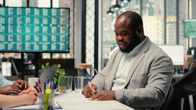 Formal interview ending with the signing of employment documents, HR expert recruiter ensures work hiring finalization. Giving his agreement to start a new role within the company. Camera B.
