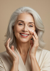 Mature woman applying facial skincare cream