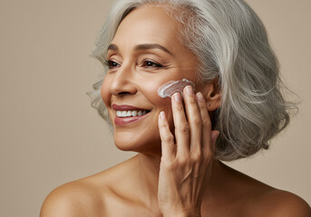 Mature woman applying facial skincare cream
