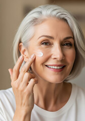 Mature woman applying facial skincare cream