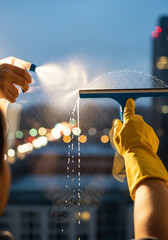 Window cleaning with spray bottle and squeegee in urban environment