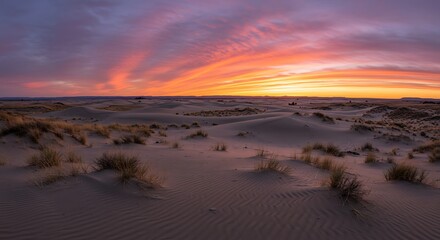 Desert landscape at sunset with colorful sky and textured sand dunes
