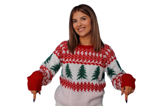 Woman wearing christmas sweater smiling and pointing down, celebrating winter holiday season on transparent background