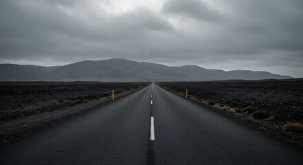 Road leading toward mountains under a cloudy sky